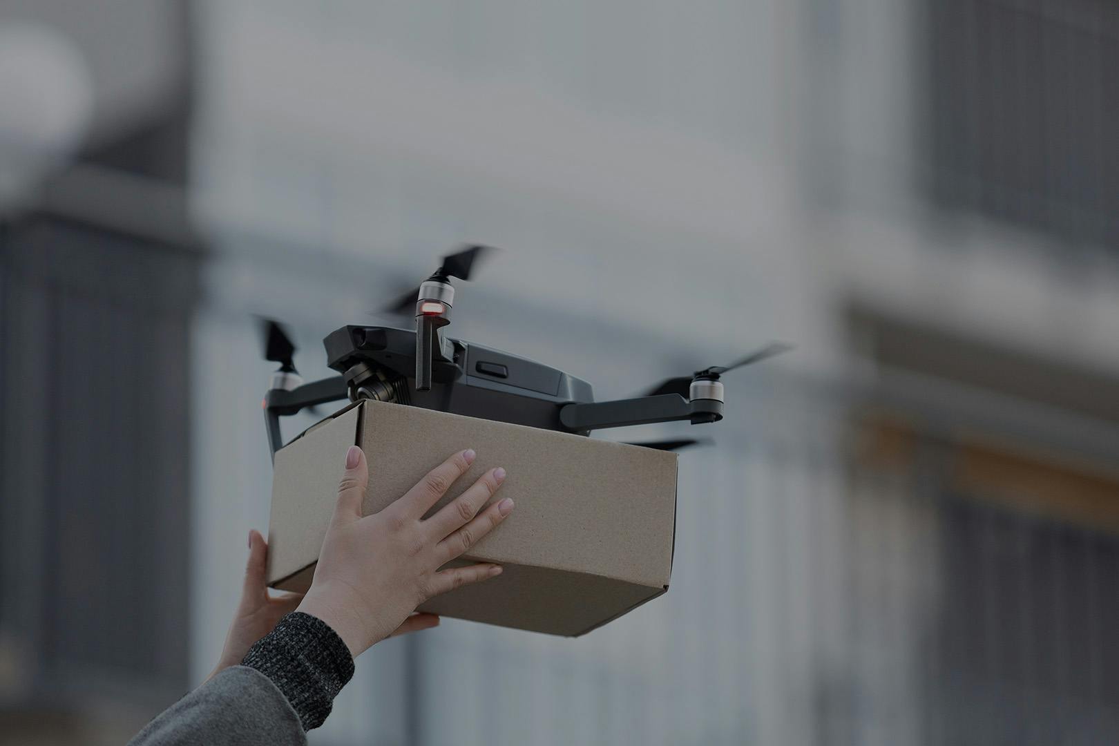Person receiving package via drone