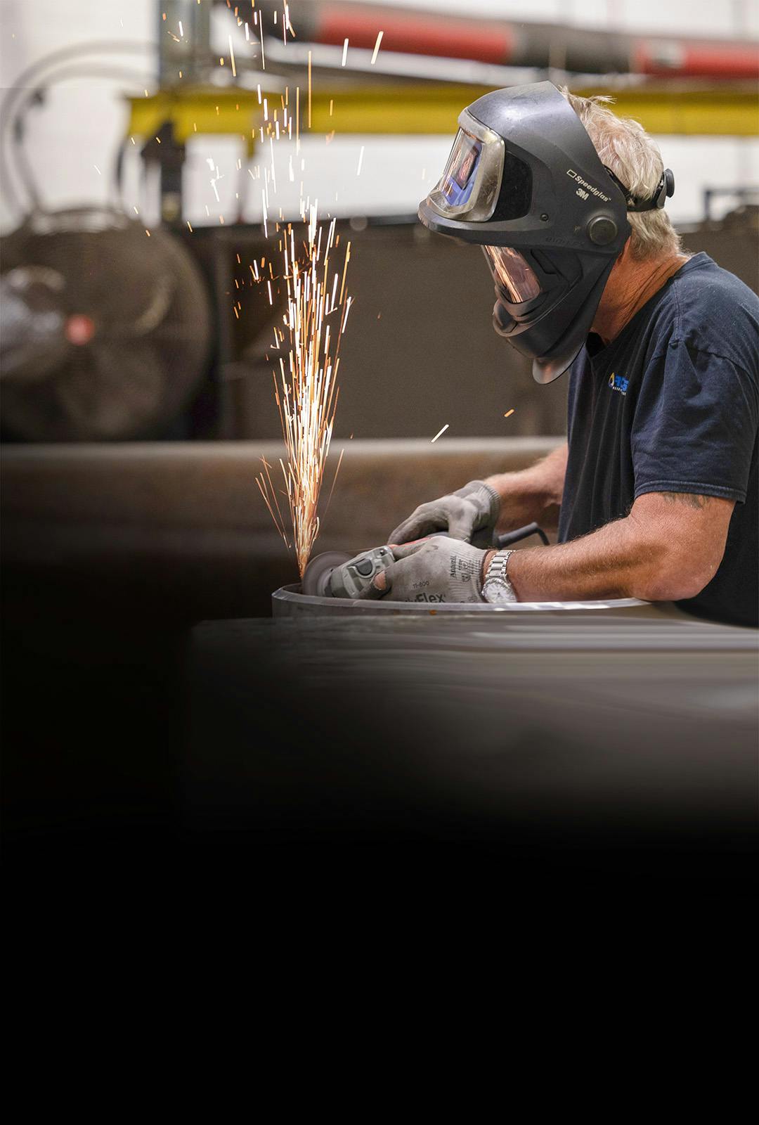 Man welding metal and sparks flying in work shop